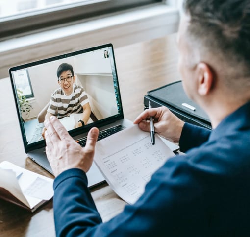 A man participating in a meeting via laptop in a professional setting