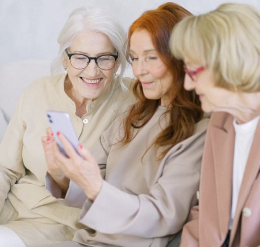 Three women engaged in a video chat using a mobile device